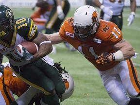 B.C. Lions Alex Hoffman-Ellis tackles Edmonton Eskimos Chad Simpson during the fourth quarter of CFL football action in Vancouver, B.C., on Thursday, August, 6, 2015.