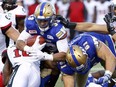 Winnipeg Blue Bomber' Andrew Harris(33) is tackled by Ottawa Redblacks' Malik Jackson (10) during pre-season CFL football action in Ottawa Monday, June 13, 2016.