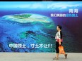 A woman walks past a poster this week of the South China Sea, with the slogan at the bottom "China's territory, never to yield an inch of our ground" on a street in Weifang, east China's Shandong province.