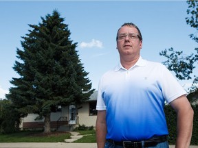 Shannon Hrehirchuk is seen in front of his north Edmonton home on Tuesday, July 12, 2016. Hrehirchuk wants to chop down the tree in his front yard (pictured at left), and is against the notion of the city having a bylaw limiting homeowners from cutting down trees on their property.
