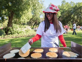 Serena Hemraj flips pancakes for the pancake breakfast, hosted by the Aga Khan Council of Edmonton, during Canada Day festivities at the Alberta Legislature in Edmonton July 1, 2016. AMBER BRACKEN/EDMONTON JOURNAL