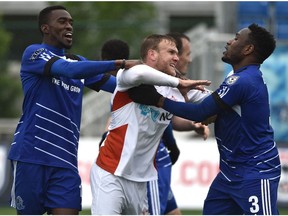 Tempers flair as FC Edmonton Tomi Ameobi, left, and Eddie Edward, right, hold back Carolina RailHawks Connor Tobin (13) from getting at a teammate during NASL at Clarke Field in Edmonton, May 22, 2016. Edward returns to play against FC Edmonton on Sunday as a member of the Ottawa Fury.