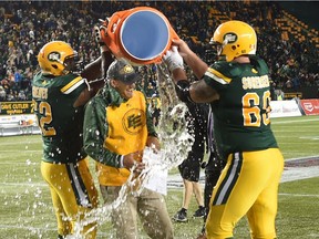 Edmonton Eskimos Chris Greaves (62) and Justin Sorensen (60) dump the water bucket over head coach Jason Maas after winning his first CFL game as coach defeating Saskatchewan Roughriders 39-36 at Commonwealth Stadium in Edmonton, Friday, July 8, 2016.