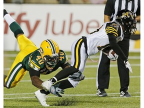 Edmonton Eskimos Deon Lacey tackles Hamilton Tiger-Cats kick returner Brandon Banks during second half of their game at Commonwealth Stadium in Edmonton last season. The Ticats were the only team to beat the Eskimos at home last season. The two teams face each other again Saturday.