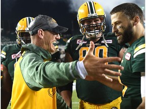 Edmonton Eskimos head coach Jason Maas about to embrace quarterback Mike Reilly (13) after defeating the Saskatchewan Roughriders 39-36 in overtime at Commonwealth Stadium in Edmonton, Friday, July 8, 2016.