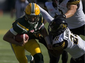 Edmonton Eskimos Mike Reilly (13) breaks away from Hamilton Tiger-Cats Beau Landry (23) during first half action at Commonwealth Stadium on Saturday, July 23, 2016 in Edmonton. Greg Southam / Postmedia Photos for various stories, columns (Gerry Moddejonge, terry Jones, Dan Barnes) running in Sunday, July 24 edition.