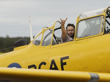 Edmonton Journal reporter Juris Graney raises "the horns" after an exciting ride with Yellow Thunder pilot David Watson in his Harvard airplane at Villeneuve Airport ahead of the Edmonton Air Show in Sturgeon County, on Thursday, July 21, 2016.