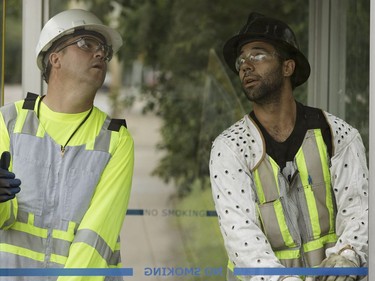 Edmonton Transit System utility workers Robert Young (left) and Pono Vey replace a broken glass panel at a bus shop on 107 Avenue near 120 Street in Edmonton, on Wednesday, July 20, 2016.