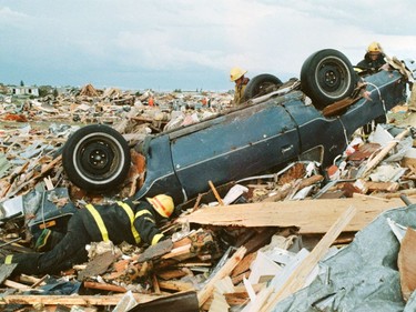 Firefighters look through the devastation for survivors or bodies at the Evergreen Mobile Home Park after a massive tornado hit Edmonton on Friday July 31, 1987.