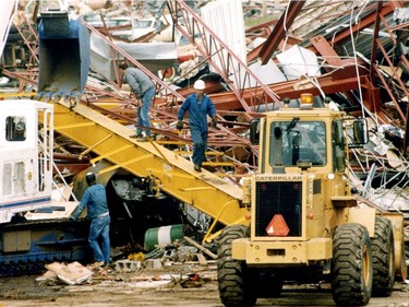 Workers get busy cleaning up the carnage on refinery row off of Baseline Rd., after a massive tornado hit Edmonton.