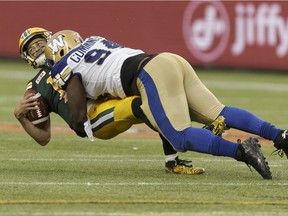 Edmonton's quarterback Mike Reilly (13) is sacked by Winnipeg's Euclid Cummings (94) during a CFL football game between the Edmonton Eskimos and the Winnipeg Blue Bombers at Commonwealth Stadium in Edmonton, on Thursday, July 28, 2016. Ian Kucerak / Postmedia (For Edmonton Journal/Sun story by Gerry Moddejonge)