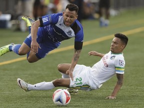 Edmonton's Shawn Nicklaw, left, is taken down by New York's David Diosa during NASL soccer play between FC Edmonton and the New York Cosmos at Clarke Stadium in Edmonton, on Wednesday, July 27, 2016. Nicklaw is one of a number of new acquisitions by Edmonton.