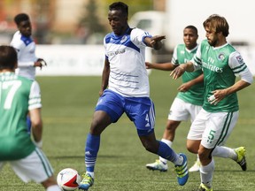 Edmonton's Papé Diakité (4) carries the ball through New York defenders during a NASL soccer game between FC Edmonton and the New York Cosmos at Clarke Stadium in Edmonton, Alta., on Sunday May 15, 2016. Photo by Ian Kucerak