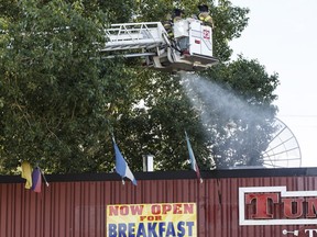 Edmonton Fire Rescue Service firefighters douse hotspots as a fire damages Tumbleweeds restaurant in Edmonton, on Sunday, July 3, 2016.