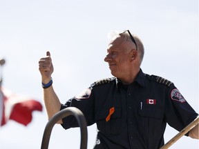 Fire Chief Darby Allen salutes the crowd during the Canada Day parade held in Fort McMurray on Friday, July 1, 2016.