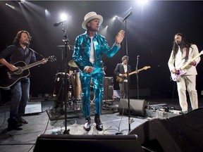 Frontman of the Tragically Hip, Gord Downie, centre, leads the band through a concert in Vancouver, Sunday, July, 24, 2016.