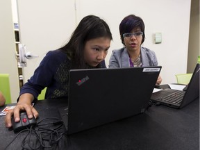 Makerspace summer programmer Sandra Sarmiento, right, helps Jasmine Li ,13, left, during a program teaching teen girls to code in HTML and other web languages at the Stanley Milner Library  on Thursday, July 21, 2016 in Edmonton.