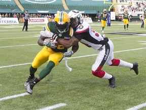 Ottawa Redblacks Jonathan Rose (34) tackles Edmonton Eskimos Joe McKnight (22) during first half CFL action in Edmonton, Alta., on Saturday, June 25, 2016.