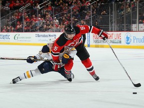 Adam Larsson eliminates Buffalo's Jack Eichel from the play and retrieves the puck.
