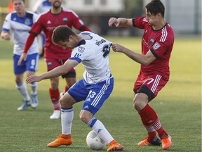 Edmonton's Jake Keegan, left, is grabbed by Ottawa's Fernando Sanfelice during an Amway Canadian Championship game on May 11, 2016. The two teams face each other again on Sunday at Clarke Stadium.