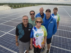 Leduc's mayor and five city councillors stand among more than 3,200 solar panels that were installed on the roof of the Leduc Recreation Centre. Front to back, on the left, is Mayor Greg Krischke, and councillors Terry Lazowski and Glen Finstad. Front to back on the left are councillors Beverly Beckett, Bob Young, and David MacKenzie.