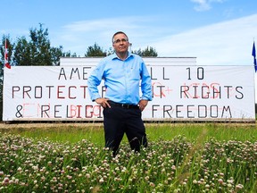 Pastor Brian Coldwell of the Harvest Baptist Academy in Spruce Grove stands in front of a billboard erected by his church on July 4, 2016.