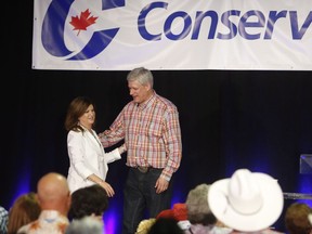 Former prime minister Stephen Harper and interim Conservative leader Rona Ambrose embrace on stage at the annual Calgary Conservative barbecue in Calgary, Saturday, July 9, 2016.