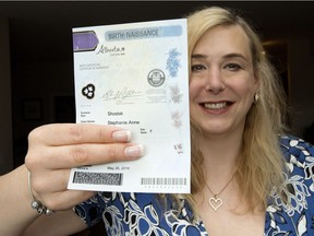 Stephanie Shostak holds her birth certificate Wednesday in her Edmonton home. Shostak is one of nearly 300 Albertans that have changed the gender marker on their birth certificate since a court decision forced Alberta to  change the rules two years ago.