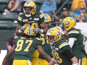 Edmonton Eskimos John White (top) and Derel Walker celebrate a touchdown against the Ottawa Redblacks during first half CFL action in Edmonton, Alta., on Saturday, June 25, 2016.