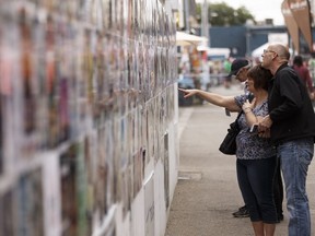 Fringers check out production posters during the 2016 Edmonton Fringe Theatre on Friday, Aug. 19, 2016.