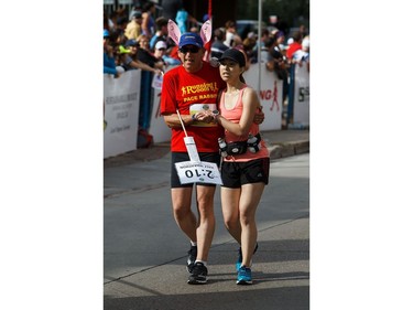A runner is helped over the finish line during the Edmonton Marathon on Sunday, Aug. 21, 2016.