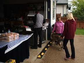 Abasand homeowners Jason Louvelle (left) and Bernette Pelley (right)  hosted a BBQ for their neighbours on the first day of re-entry for standing homes, Wednesday, Aug. 31, 2016.  Olivia Condon/ Fort McMurray Today/ Postmedia Network