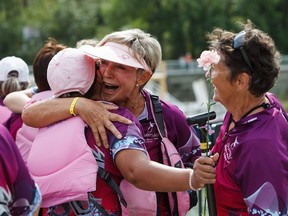 Cancer survivors embrace one another after the Pink Ribbon Challenge at the Edmonton Dragon Boat Festival in Edmonton, Alta., on Sunday, Aug. 21, 2016.