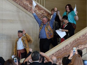 Metis National Council President Clement Chartier, left, and David Chartrand, president of the Manitoba Metis Federation, middle, celebrate following a decision at the Supreme Court of Canada in Ottawa on Thursday, April 14, 2016.