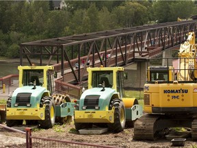 Pedestrians used the Cloverdale footbridge across the North Saskatchewan River on July 11, 2016, while heavy equipment awaited dryer conditions. The bridge is to be demolished to make way for the Valley Line LRT project.