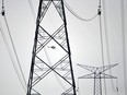 A helicopter delivers materials and tools to workers stringing up high tension power lines on giant new towers east of Clareview in Edmonton in a 2013 file photo.