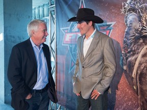 Oilers Entertainment Group Vice Chair and CEO Bob Nicholson laughs with bull rider Zane Lambert during a press conference announcing a new partnership with Professional Bull Riders at EPCOR Tower in Edmonton August 3, 2016.