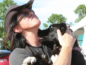 Mike Farris hugs the dog he adopted in Edmonton  after his performance  at the Edmonton Folk Music Festival in 2015.