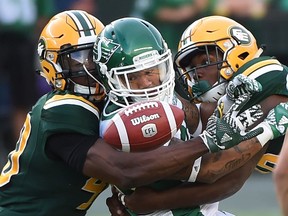 Edmonton Eskimos Deon Lacey (40) and Doug Parrish (16) knock the ball from Saskatchewan Roughriders Kendial Lawrence (32) but the Roughriders recover the fumble during CFL action at Commonwealth Stadium in Edmonton, Friday, July 8, 2016. Ed Kaiser/Postmedia (For Edmonton Journal story by Dan Barnes)