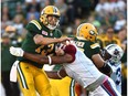 Edmonton Eskimos quarterback Mike Reilly (13) gets hit after throwing the ball by Montreal Alouettes John Bowman (7) during CFL action at Commonwealth Stadium in Edmonton Friday, August 11, 2016.