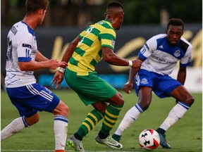 FC Edmonton midfielder Jake Keegan, left,  and striker Tomi Ameobi, right, challenge Tampa Bay Rowdies defender Darnell King for the ball in North America Soccer League play Saturday in Tampa, Florida. FC Edmonton won 1-0.