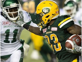 Edmonton Eskimos running back Shakir Bell, right, tries to fight off Saskatchewan Roughriders Ed Gainey during second half CFL action at Commonwealth Stadium, in Edmonton on Friday Aug. 26, 2016. Bell received a face mask penalty on the play.