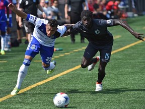 FC Edmonton's Shawn Nicklaw, left, battels with Minnesota United FC's Ismaila Jome as they eye the ball during NASL action at Clarke Stadium on Sunday.