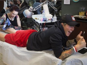 Jen Kish, captain of Canada's bronze-medal winning women's sevens rugby team, gets an Olympic torch tattoo from Jen Danger Saturday.