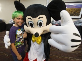 Gavin Dale, 10, of Fort McMurray poses for a photo with Mickey Mouse after learning he and 150 other children will receive a free trip to Disneyland from Dreams Take Flight Edmonton, at the DoubleTree by Hinton Hotel, 16615 - 109 Ave., in Edmonton on Sunday, Aug. 28, 2016.