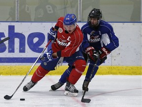 Lane Bauer (left) is checked by Dorian Hall (right) during an Edmonton Oil Kings training camp scrimmage game at the Dow Centennial Centre in Fort Saskatchewan, Alberta on Aug. 29, 2016.
