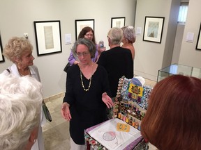 Marlena Wyman, centre, shows her exhibit, Illuminating the Diary of Alda Dale Randall, to members of the Randall family at the Provincial Archives of Alberta.