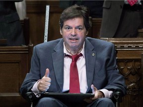 Ottawa-Vanier MP Mauril Belanger gives the thumbs up as he receives applause after using a tablet with text-to-speech program to defend his proposed changes to neutralize gender in the lyrics to "O Canada" in the House of Commons on Parliament Hill in Ottawa in May.