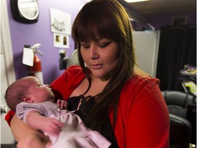 Janine Cardinal holds one month old daughter Britney. Cardinal, a single mother receiving income support, says it's hard to get by on the income provided.