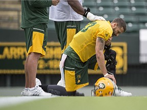 Offensive Lineman Tony Washington places his hand on the back of quarterback Mike Reilly at the Edmonton Eskimos practice at Commonwealth Stadium on Aug. 9, 2016.